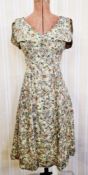 A mid twentieth century day dress, possibly silk, floral pattern, sleeveless but with cap sleeves