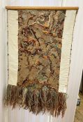 A wall hanging of a multitude of wools and strings in knitting, stitching and knotting, creating a