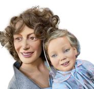 A fibreglass life-size mannequin/model of a seated woman holding a small child on her lap, vintage