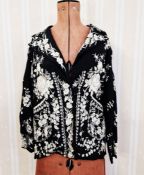 An early 20th century Chinese silk jacket, embroidered with white peonies, white silk lining with