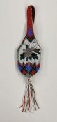 A Native American beaded purse with a wrist strap beaded handle and tassel , the colours vibrant