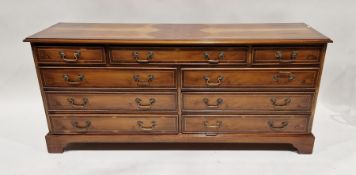 Reproduction walnut sideboard with an arrangement of nine drawers, on bracket feet, 67cm high x
