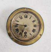 Small brass ship's bulkhead clock, brass face and black painted roman numerals, mounted on wooden