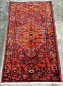 North west Persian red ground Zanjan rug with central hooked geometric medallion enclosing floral