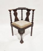 Carved and stained oak corner armchair with foliate carved bow top rail and twin splat-back,