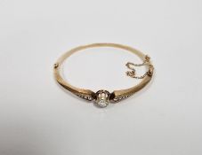 Gold and diamond set bangle, the central old cut diamond 6mm diameter approx., flanked by five