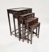 Nest of four Chinese hardwood occasional tables, each rectangular with pierced fruit and foliate