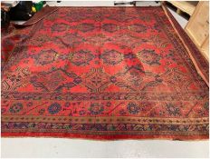 Large square red ground carpet with three rows of five and two rows of four geometric medallions,