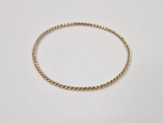 Twisted gold-coloured metal bangle, 6.5g approx. Condition ReportThis bangle tests as 9ct gold or