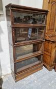 Globe Wernicke glazed sectional bookcase of four tiers, each with lift up door, on shaped plinth