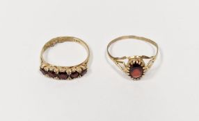 9ct gold and oval garnet set ring and a 9ct gold and garnet five-stone ring, 3.5g total approx. (2)