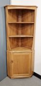 Ercol blonde windsor corner cabinet with three shelves above cupboard below, 177cm high