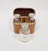 Leather cased silver-plated lidded three-glass bottle set, initialled to case R.G.Condition