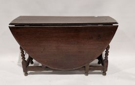 Late 18th/early 19th century oak gateleg dining table of oval form, with turned supports, on bun