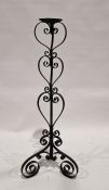 20th century black painted floor standing candle stand, with scrolling decoration throughout,