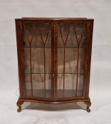 20th century bowfronted mahogany glazed display cabinet, the two doors opening to reveal two glass