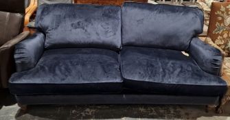 Contemporary navy blue velvet sofa by Marks & Spencers, raised on turned wooden feet, 90cm high x