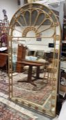 Large gilt framed mirror with arched top decorated with circular pierced and carved gilt floral