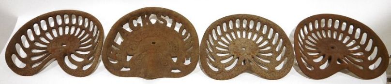 Four vintage cast iron tractor seats, two seats by Bamfords, one marked 'Hornsby' and one by