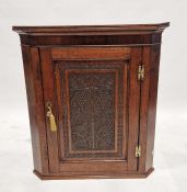 Georgian oak wall hanging corner cabinet with later carved panel to the door of grape and vine