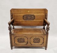 Oak monk's bench with carved scrolling foliate decoration to the seat, back and front panels,