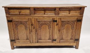 Reproduction oak sideboard having three drawers above three cupboards with carved arched panel