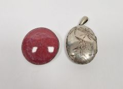 Victorian silver-coloured locket, oval, and a Ruskin-style silver-mounted circular pottery brooch (