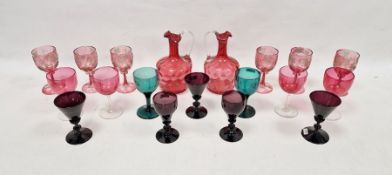 Two Victorian cranberry tinted honeycomb moulded ewers, six wine-glasses engraved with fruiting