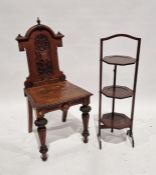 Victorian stained oak hall chair with ornate carved shield and scrolling motifs to the back, 97cm