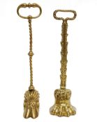 Brass claw and feather-pattern doorstop with loop handle and another with cloven hoof (2)