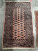Persian style orange ground rug with two rows of fourteen elephant foot guls and one row of thirteen