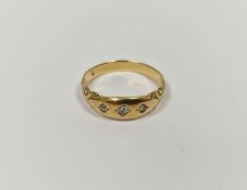 Gold-coloured metal and diamond ring set three old cut diamonds in gold band with scroll shoulders