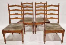 Four pine ladderback dining chairs, with carved detail to the top rail, turned front supports,