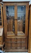 Modern stained oak display cabinet, the two doors fitted with bevel-edged glass panels and having
