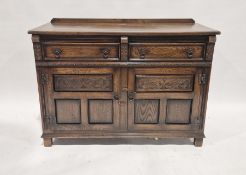 Reproduction dark stained oak sideboard fitted two frieze drawers over two carved panelled doors, on