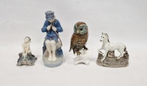 Royal Copenhagen model of a fisher boy, model no.079, seated on rockwork, on a shaped oval base,