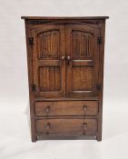 Oak reproduction linen cabinet enclosed by linen fold panel doors over two drawers, 122cm high x