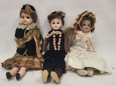 Three late 19th/early 20th century dolls, comprising: a wax shoulder head doll, with blue glass