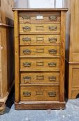 Edwardian oak Wellington chest of seven graduated drawers, each with brass floral plates and drop