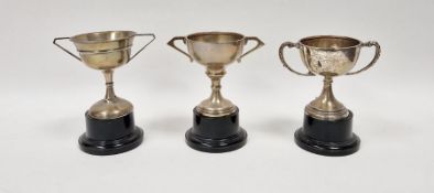 Three early to mid 20th century unengraved silver trophies, one with weighted base, each having twin