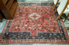 Eastern red ground with central lozenge medallion on stylised animal and floral field, multiple