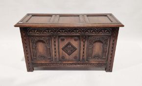 Reproduction oak coffer with carved panel front and three panelled cover, panelled side, 58cm high x