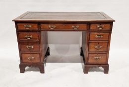 Early 20th century walnut kneehole pedestal desk with brown tooled leather inset top over an