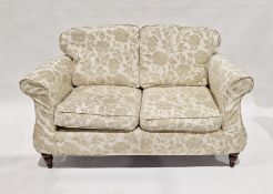 Two-seat settee on turned supports with loose squab cushions, with floral patterned upholstery
