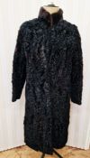 A black Astrakhan fur coat with a mink collar