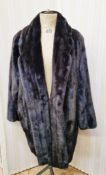 A black saga mink coat, labelled 