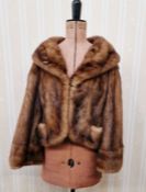 A 1950's mink jacket, the banded waist band, a full shawl collar, bell sleeves, embroidered satin