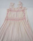 Two vintage night dresses with smocked detail to the neckline and bodice, one pink, one blue, a