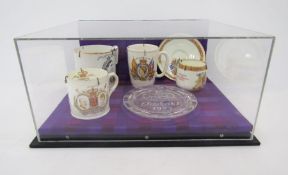 Collection of Royal Commemorative ceramics and glass within a perspex display case, including a