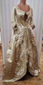 An early Victorian cream satin wedding dress, worn in 1847, the overdress is adorned with ruffles,